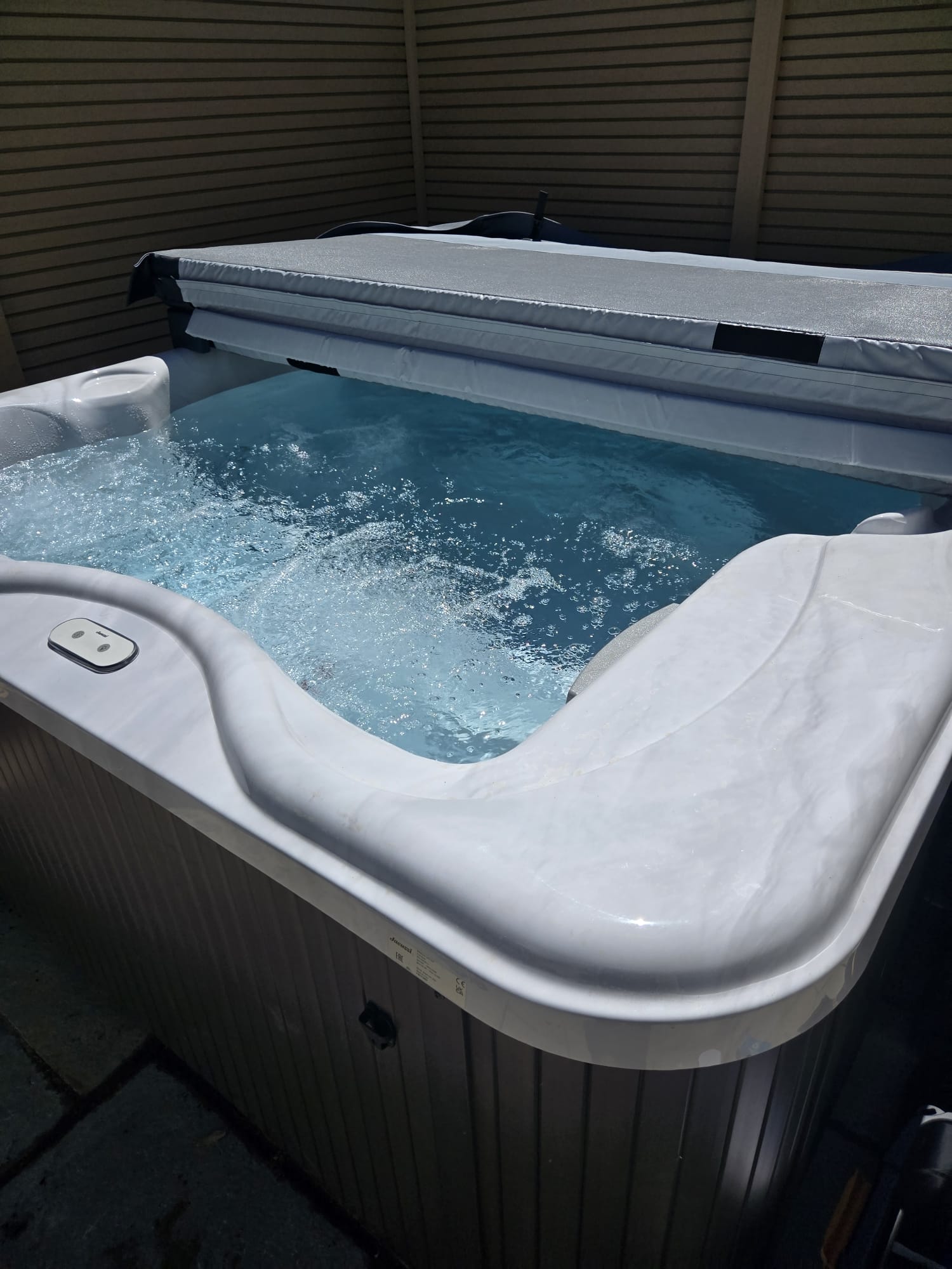 The hot tub at 3 Parc Merys, bubbling beside timber screening