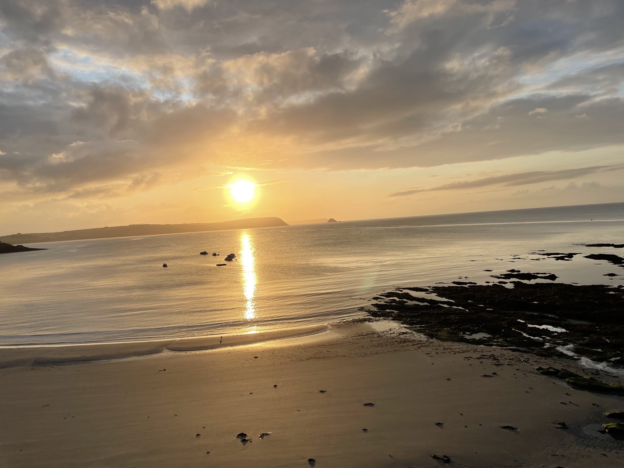 Golden morning light reflected across the sea and wet sand on the Roseland